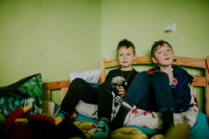 Kranke Mutter, wohin mit den Kindern: zwei Jungs (circa 10 Jahre) lümmeln im Trainingsanzug auf einem Bett