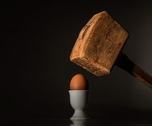Ratschläge: großer Holzhammer zerschlägt kleines Ei