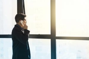 Kommunikationssperre Gordon: Geschäftsmann telefoniert mit Handy und blickt in die Ferne