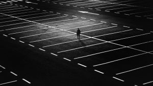 ein Mann allein im Regen auf Parkplatz-wirkt einsam und traurig