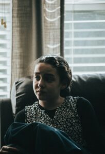 junge frau mit traurigem Blick im dunklen zimmer