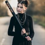 Schwarz gekleidetes Mädchen im Teenageralter mit Baseballschläger in der Hand – Symbolbild für das Bedürfnis hinter der Wut