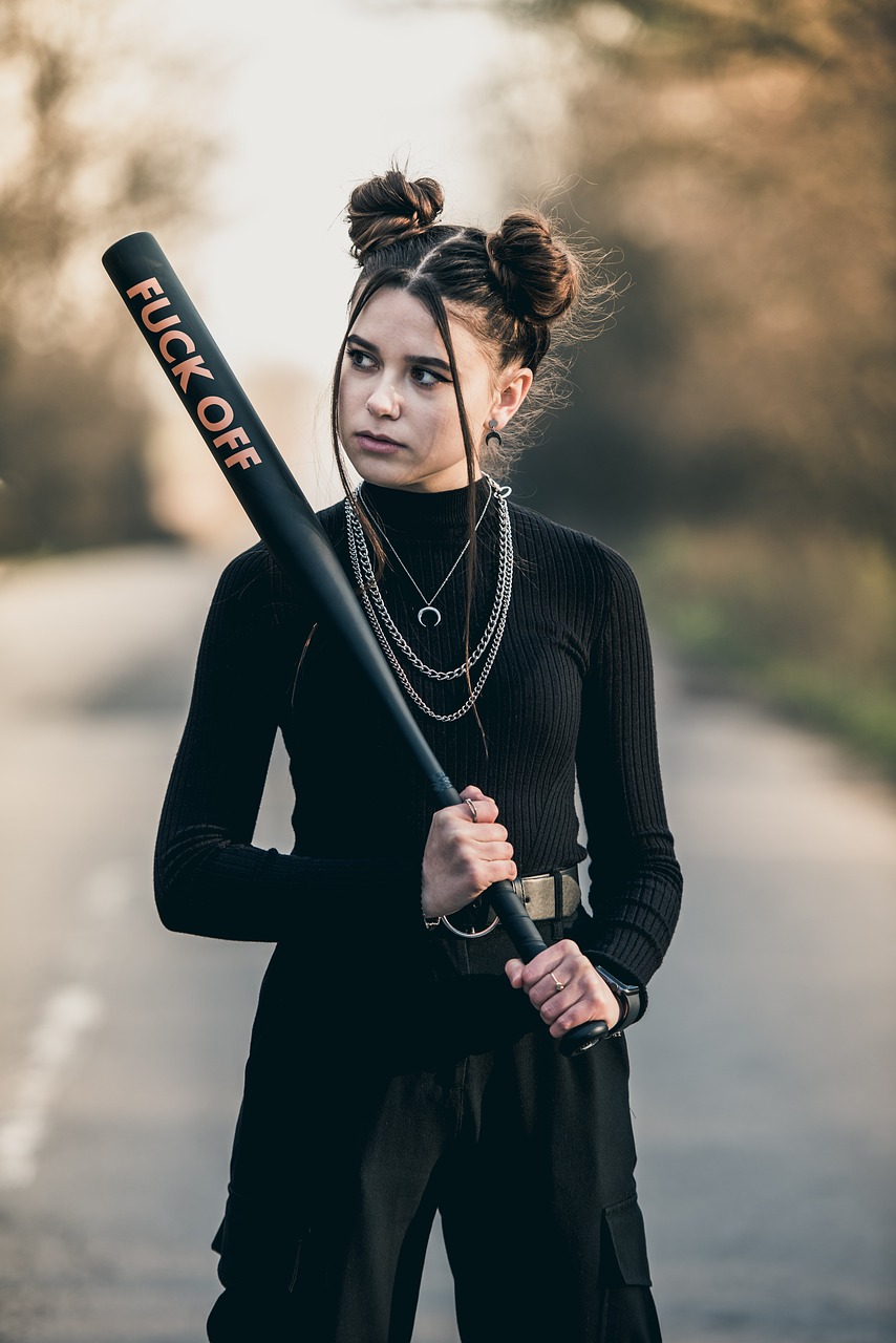Schwarz gekleidetes Mädchen im Teenageralter mit Baseballschläger in der Hand – Symbolbild für das Bedürfnis hinter der Wut