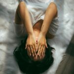 ACE-Studie einfach erklärt: die 10 Arten von Kindheitstraumata Eine Person hält sich die Hände vors Gesicht