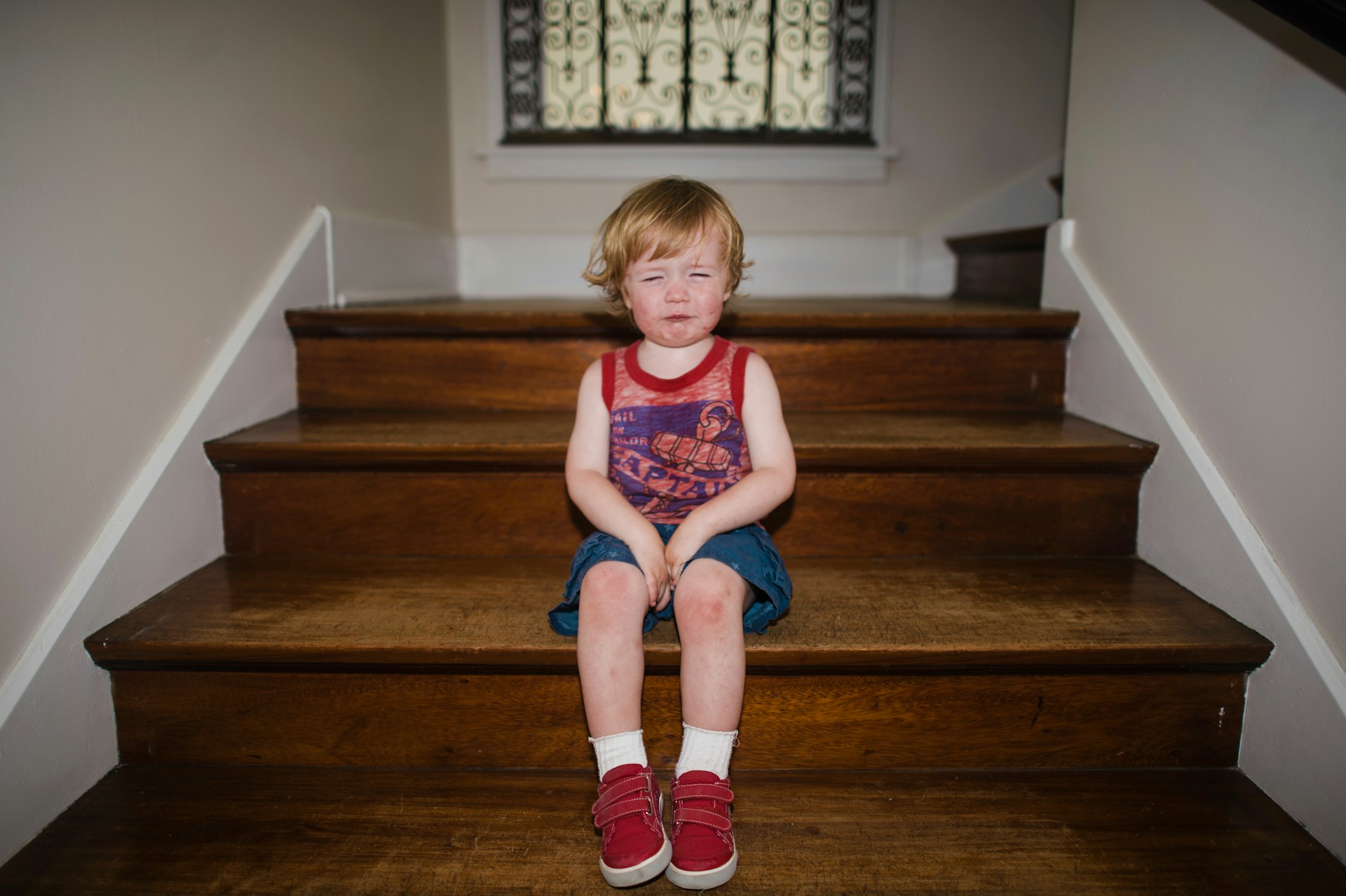 Weinendes Mädchen sitzt allein auf einer Treppe – Symbolbild für Existenztrauma und Bindungstrauma in der Kindheit